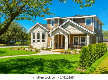 Brand new house for sale. Big luxury house with nicely trimmed and landscaped front yard lawn in the suburbs of Vancouver, Canada. 