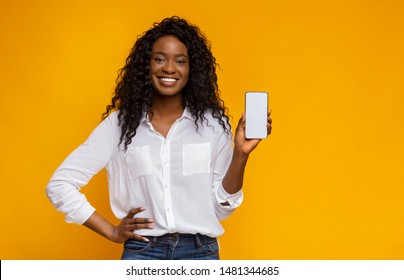 Brand New Mobile Phone. Cheerful African American Woman Showing Latest Slim Smartphone With Blank Screen, Copy Space