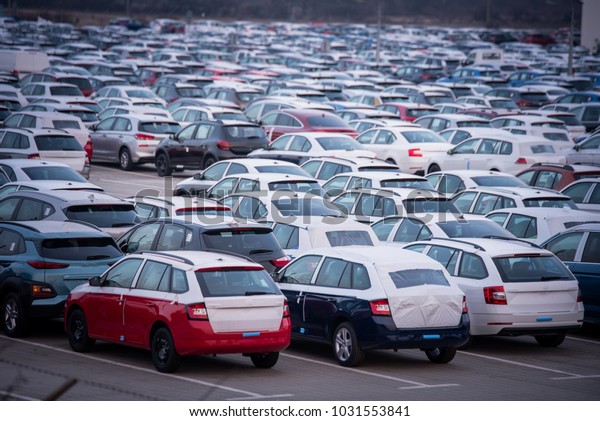 Brand new motor vehicles in a parking lot waiting\
for export