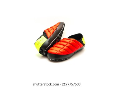 Brand new pair of red and green slip-on shoes mules with high-traction rubber outsole isolated on white background. Ripstop upper, collapsible heel warmth and comfort sneaker footgear.