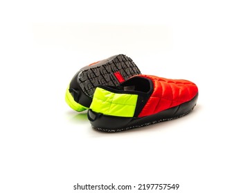 Brand new pair of red and green slip-on shoes mules with high-traction rubber outsole isolated on white background. Ripstop upper, collapsible heel warmth and comfort sneaker footgear.