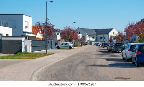 Brand New Residential House With Car Parked On Driveway In Front. Big Family House With Double Garage Door And Blue Sky Background. British Columbia, Canada.