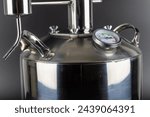 brand new stainless steel alcohol machine or moonshine still on black background.