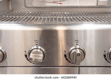 Brand New Stainless Steel Natural Gas Grill On Display In Store At Humble, Texas, US. Close-up Of Grill Knobs With Solid Cooking Grates, Stainless Steel Rods And Warming Rack.