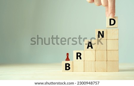 Brand strategy concept. Developing a strong brand strategy differentiate from competitors and build loyalty with customers. Wooden cube blocks with BRAND text and strategy icon on clean background.