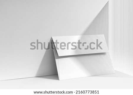 Branding envelope mockup template, with sharp natural shadows, real photo. Blank isolated on a white background to place your design. 