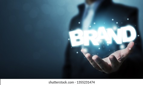 Branding Idea Concept. Businessman Hand Holding Word BRAND With Bokeh Background