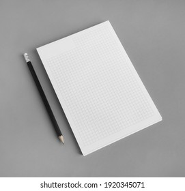 Branding stationery mockup. Copybook and pencil on gray paper background. Blank objects for placing your design.