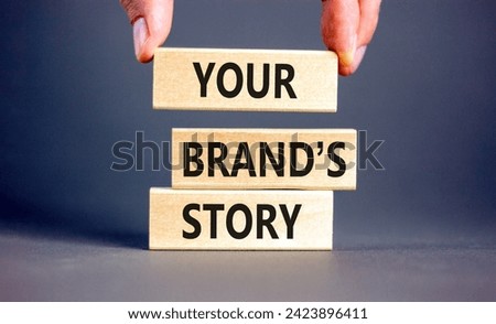 Branding and your brand story symbol. Concept words Your brands story on beautiful wooden blocks. Beautiful grey background. Businessman hand. Business branding your brand story concept. Copy space.