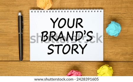 Branding and your brand story symbol. Concept words Your brands story on beautiful white note. Beautiful wooden background. Pen. Colored paper. Business branding your brand story concept. Copy space.