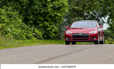 BRANT, CANADA - July 16, 2019: Red Tesla Model S seen driving down a road.