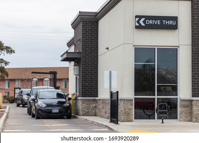 BRANTFORD, CANADA - March 26, 2020: Vehicles in the drive-thru at a Starbucks Coffee location using drive-thru pick up only due to the ongoing COVID-19 Pandemic. 
