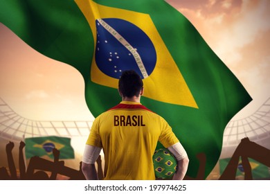 Brasil Football Player Holding Ball Against Large Football Stadium Under Cloudy Blue Sky