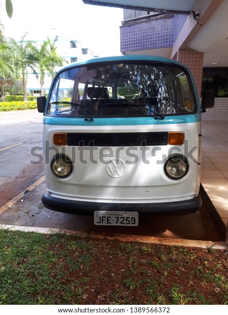 Brasilia, Brazil,\
May 27, 2019: Kombi front, standard turquoise and white, produced\
by volkswagen, utility car, sturdy, vintage designer, in parking\
lot of the Brazilian\
capital.
