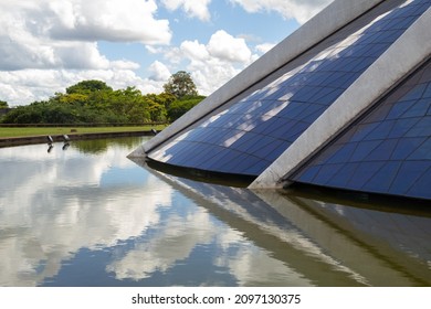 BRASILIA FEDERAL DISTRICT BRAZIL – DECEMBER 25 2021:  Detail Of The Metropolitan Cathedral Of Brasília With The Water Mirror And Cloudy Sky In The Background.