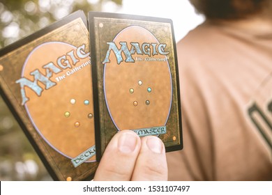 Brasilia, Federal District - Brazil. October, 14,  2019. Man holding up game cards: "Magic: the Gathering."