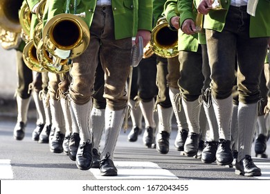 A brass band in leather pants marches in step - Leather pants is the general term for a short or long pants made of leather. 
