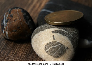 Brass Coin On Colored Stone. The Edge Of The Coin.