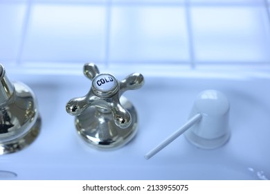 A Brass Faucet Knob Labeled “cold”