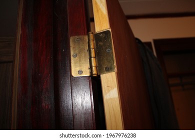 Brass Hinge Hanging On A Door Frame 