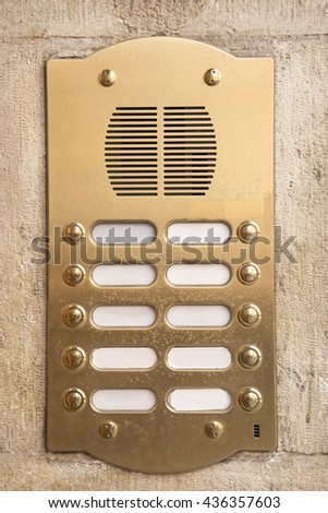 Brass intercom on a marble facade