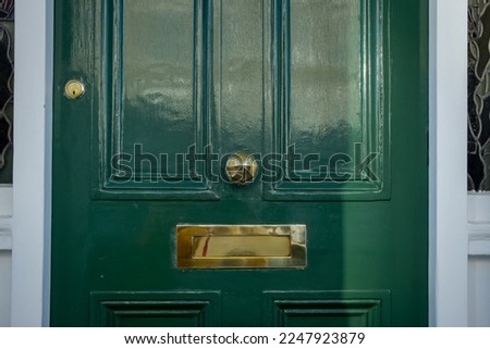 Brass letter box on green door of British house
