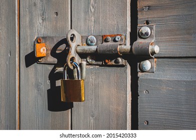 Brass Padlock With Bolt Lock On Wooden Door.