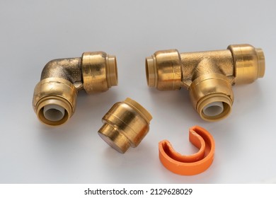 Brass plumbing parts, pipes, elbows, corners and plugs on a white background