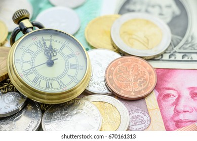 Brass Pocket Watch With Coins And Banknotes From The Most Famous Countries. Concept Of Time Vs Money Dilemma, Everyone Faces This Situation In Everyday. To Save One, We Have To Spend The Other.