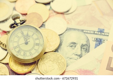 Brass Pocket Watch With Coins And Banknotes From The Most Famous Countries. Concept Of Time Vs Money Dilemma, Everyone Faces This Situation In Everyday. To Save One, We Have To Spend The Other.