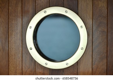 Brass Porthole Window In A Wooden Ships Door