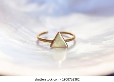 Brass Ring In Triangle Shape On White Shell Background