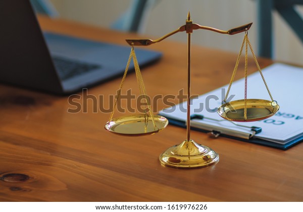 Brass scales are placed on the tables within\
the lawyer\'s office for use as decorations and as a symbol of\
justice in judicial proceedings.\
Brass scales are a symbol of\
justice in court\
hearings.