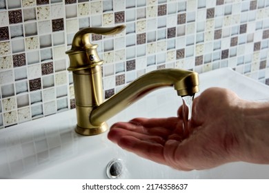 Brass Single Elbow Lever Mono Mixer Tap In Bathroom, Hand Is Checking Water Temperature.