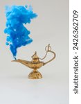 Brass vintage oil lamp on a solid white  background and blue smoke