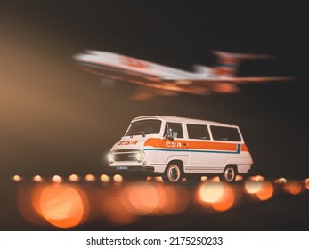 BRATISLAVA, SLOVAKIA - DECEMBER 10 2019: Oldtimer SKODA 1203 And Plane Tupolev TU-154M CSA On Runway. Scale Model Airport. Czechoslovak Airlanes. Runway Lights In Background.