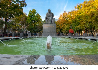 BRATISLAVA, SLOVAKIA, OCTOBER 14, 2017: A Photograph Documenting The Fountain And Statue Of Pavol Orszagh Hviezdoslav In The Old Town Of Bratislava As The Sun Lights Up The Colourful Trees In The Back