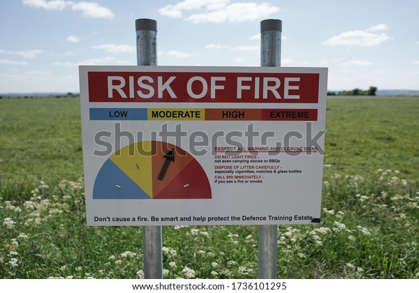Bratton Camp, UK - May\
11, 2020: A \'Risk of Fire\' sign is seen on farmland bordering a\
military firing range.