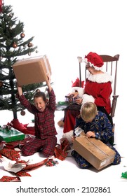 A Bratty Child Having A Tantrum Under The Christmas Tree While His Brother And Mrs. Santa Look On