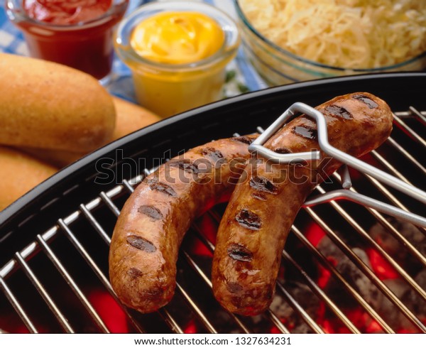bratwursts on outdoor\
grill with condiments\
