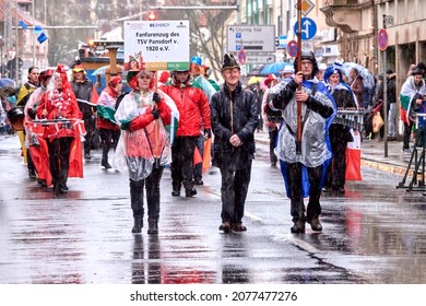 Braunschweig, Germany, February 23, 2020: Fanfare procession at the carnival parade in the downpour with transparent rainwear marches through the city center