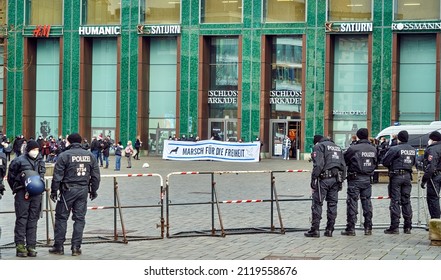 Braunschweig, Germany, January 8, 2022: Police barricade in front of protesters of a right-wing party holding a poster demanding freedom in front of a shopping center