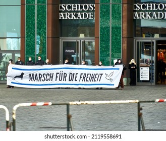 Braunschweig, Germany, January 8, 2022: Members of a right-wing extremist party wearing respirator masks hold a placard behind a barricade reading "March for Freedom"