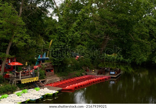 Braunschweig, Germany - June 07, 2022: red\
paddleboats are at the boat rental at the river\
Oker