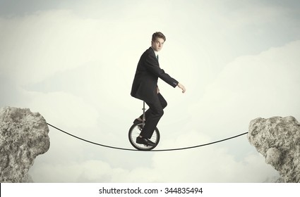 Brave business man riding an mono cycle between cliffs concept - Shutterstock ID 344835494