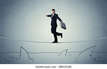 A Brave Businessman Walking On Tightrope Expanded Aboved Rawn Ocean With Shark Fin Concept