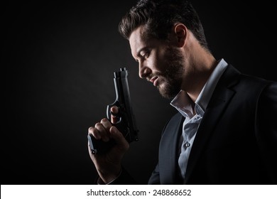 Brave Cool Man Holding A Gun On Dark Background