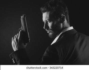 Brave Cool Man Holding A Gun On Dark Background