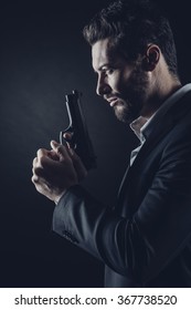 Brave Cool Man Holding A Gun On Dark Background