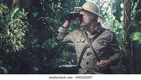 Brave explorer walking alone in the jungle he is looking through binoculars - Shutterstock ID 1945333297